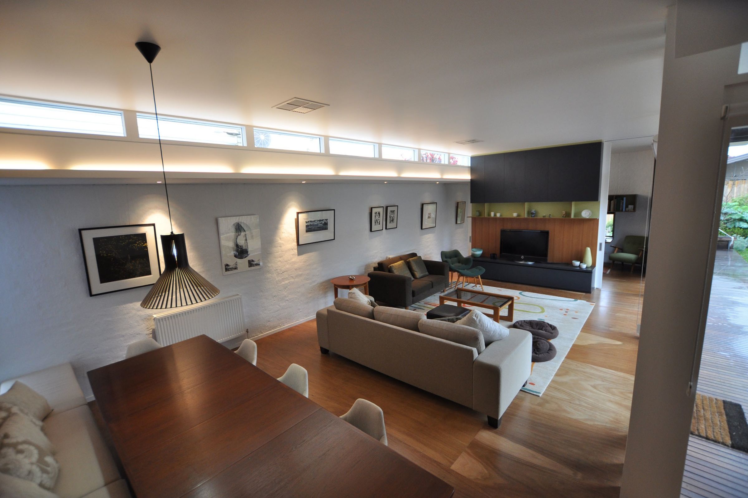 Preston Residence open-plan living space with pendant, brick wall, and timber floor